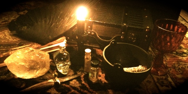 various altar tools including a knife, crystal, cauldron, candle, etc.