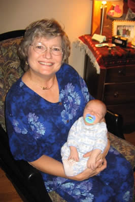 an older caucasian woman holding her infant grandson
