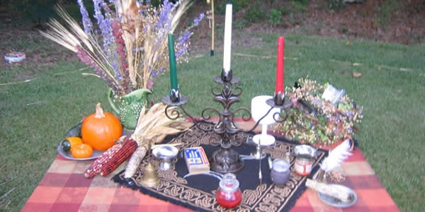 an altar on a table consisting of three candles and some other paraphrenalia