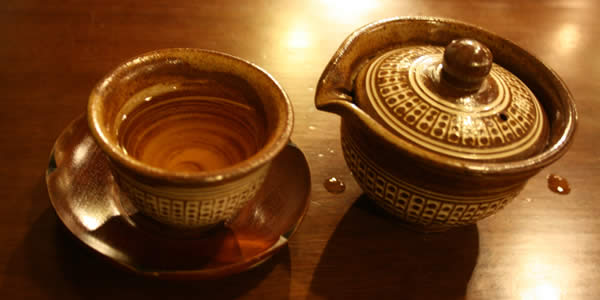 a teapot, an empty tea cup, and a saucer