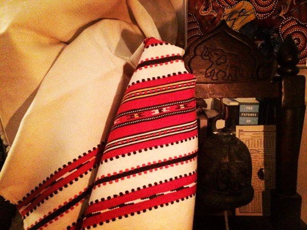 an off-white woven blanket with red accent banding