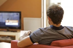 Rear view of young man watching television
