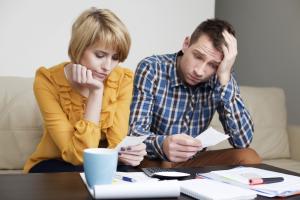 Sad young couple paying bills.