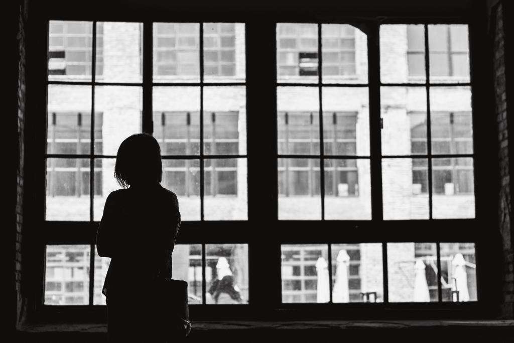 Woman staring longingly out a widow