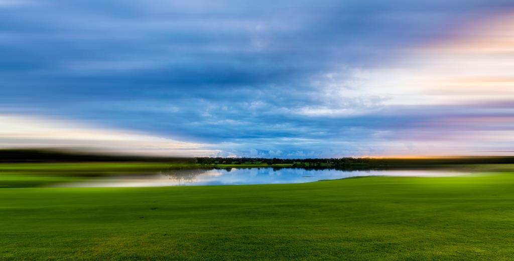 Photo by Igor Kasalovic on Unsplash sunrise over a green pasture and a pond
