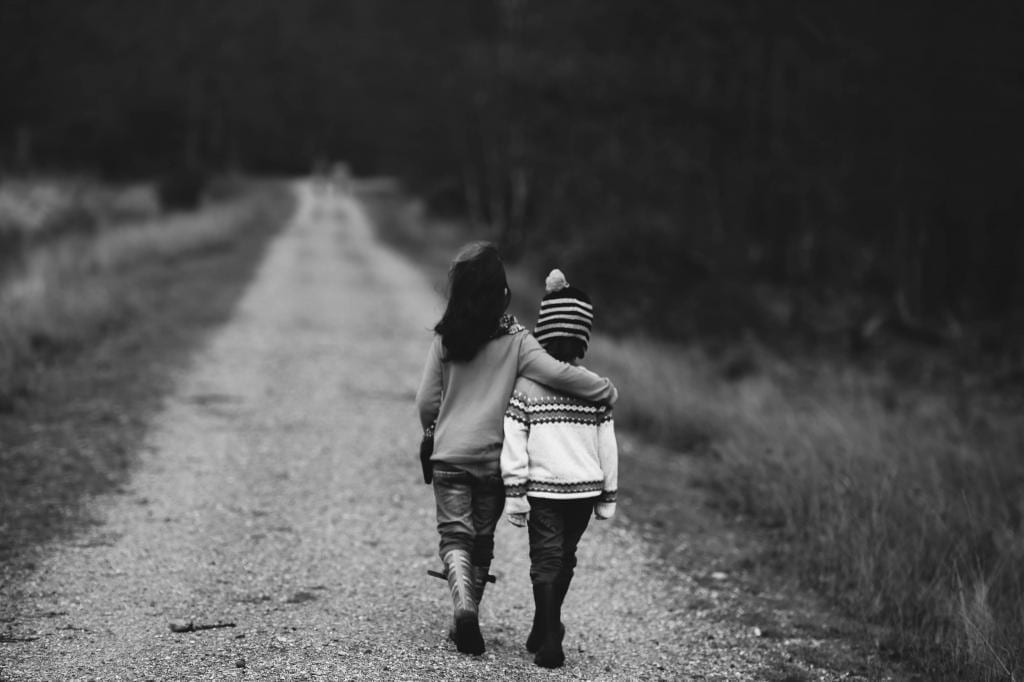 Kids walking down dirt road.