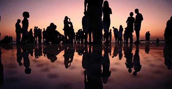 Picture of people standing on reflective mirror surface.