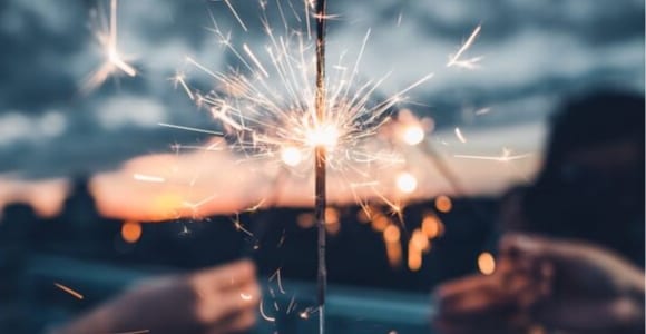 photo of person holding lighted sparkler