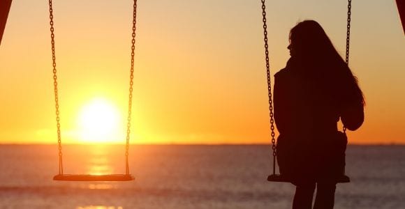 woman sitting alone on swing set