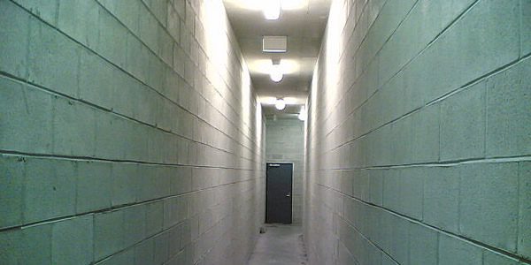 An empty hallway with a closed door at the end.