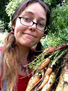 photograph of the author holding recently harvested carrots