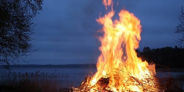 A bonfire at night near a lake