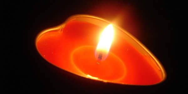 a heart shaped lit candle