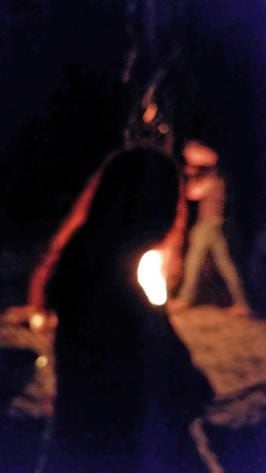 A female silhouette in front of a ritual fire