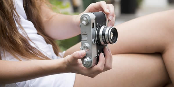 a young, white woman holding a camera
