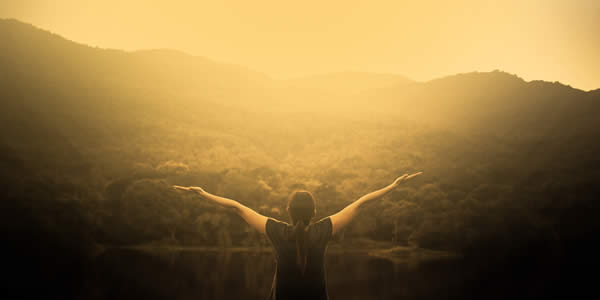 a woman facing away from the camera with her arms raised 