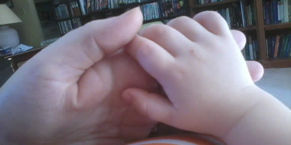 an adult's and a child's clasped hands