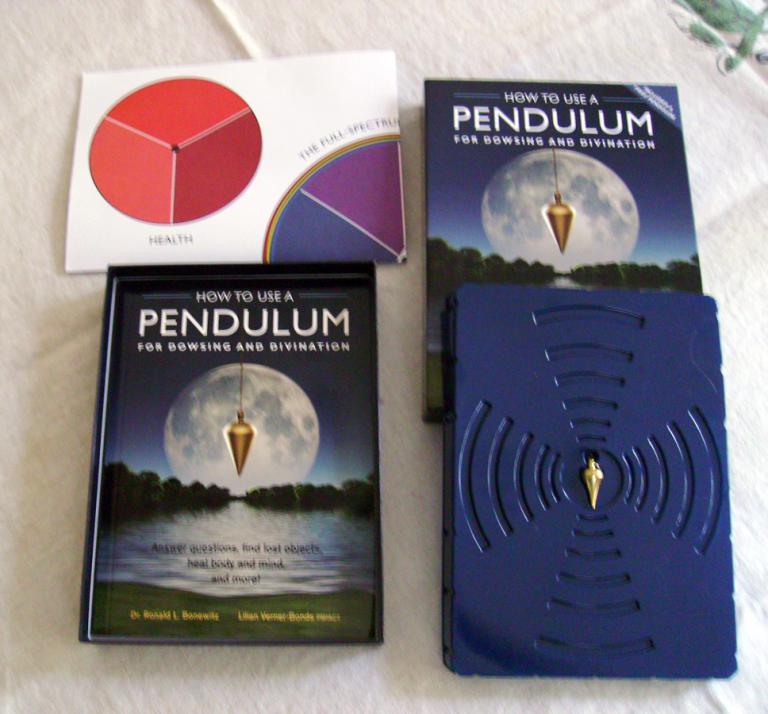 Contents of the Box including the book, a pendulum, and other divination supplies / Photo by Dana Corby