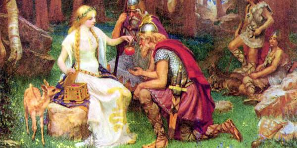 a blond woman hands apples to other men and women in chain mail