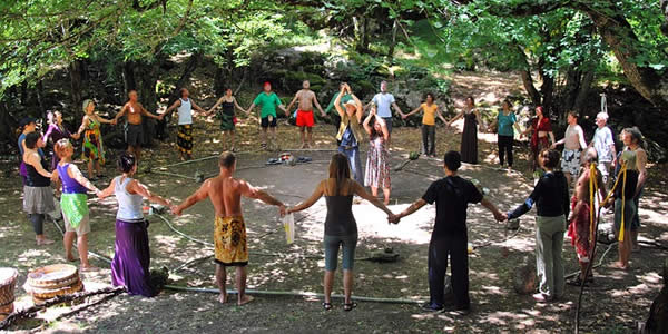 a group of people in a circle holding hands as two more people stand in the center speaking to them