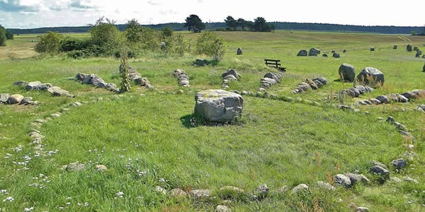 a stone circle with a center altar on a green hilltop