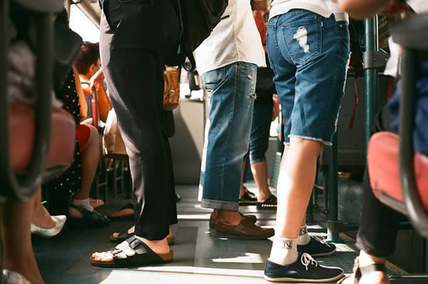 the legs of those standing to ride on a subway car