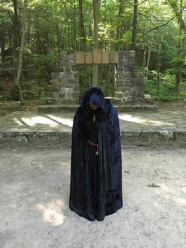 a woman in a black, hooded robe