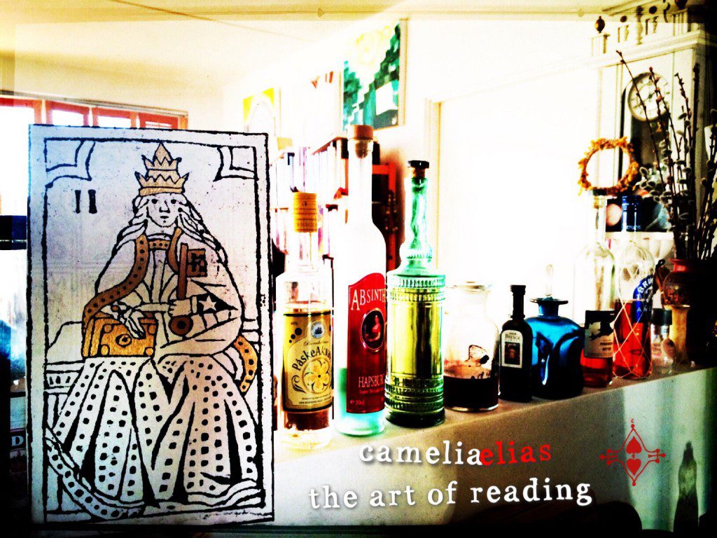 a tarot card in the foreground with a living room in the background; the image includes the phrase"camelia elias, the art of reading"