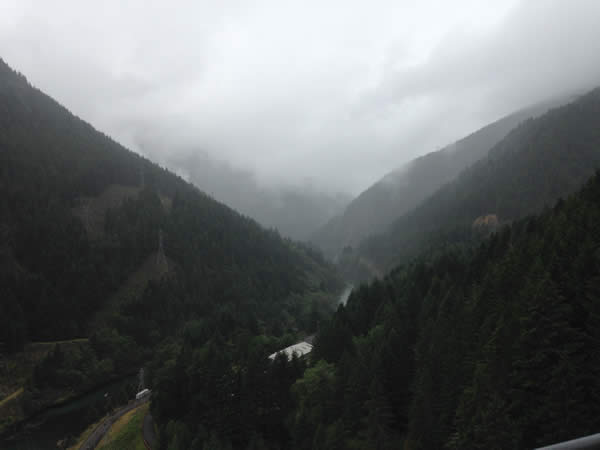 a valley between mountains with a river beneath