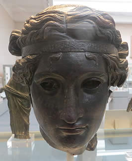 a bronze mask of a young man