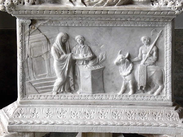 a marble relief depicting three people sacrificing a cow or bull