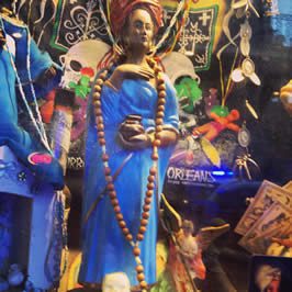 a statue of a woman in a blue dress adorned with a rosary