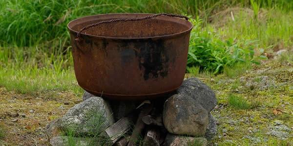 a cauldron placed outside on a firepit