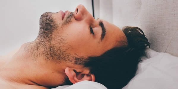 a young man sleeping on his back