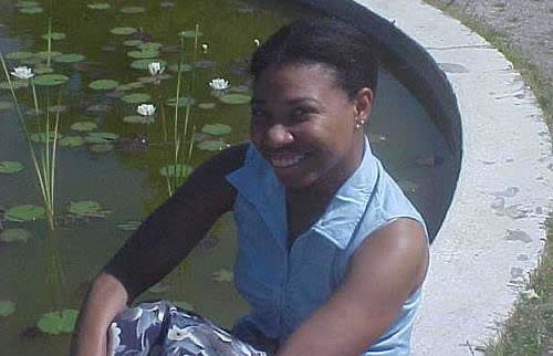 a photograph of Tish Gill, an African-American woman, seated next to a pond