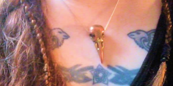 the author wearing a bronze pendant shaped like a bird's skull