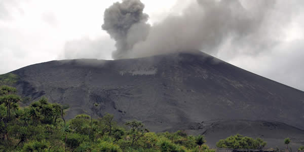 a photograph of a volcano as smoke and ash rises from its crater