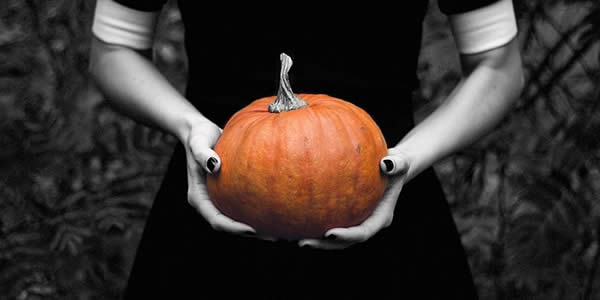 a woman holding a pumpkin before her