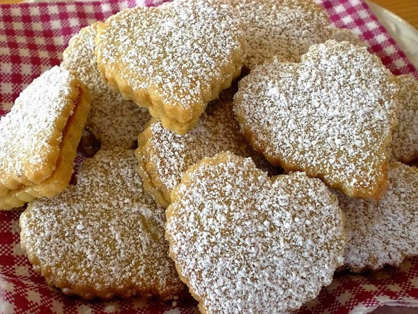 heart-shaped, sugar-dusted cookies arranged on a plate