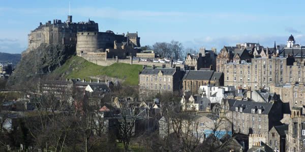 a photograph of edinbrug castle on a sunny, cloudless day including portions of the surrounding city