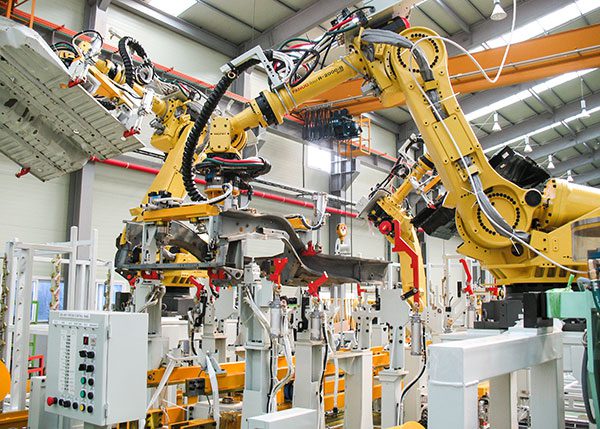 an industrial robot, looking like a very large arm, adjusts the placement of material in in a room