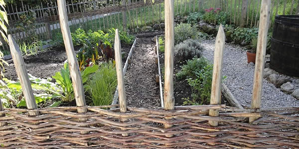 a fenced herb garden arranged in terraces on a hillside