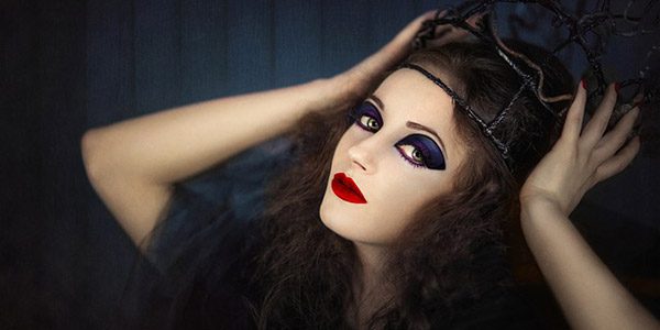 a model in makeup, including red lipstick and purple eyeshadow