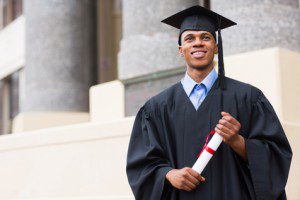 Young graduate standing in front of university building