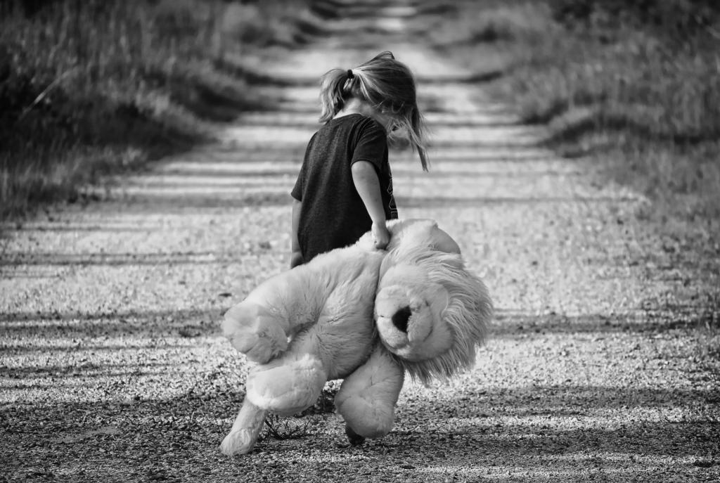 Grayscale Photography of Girl Holding Plush Toy