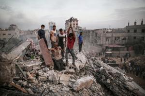 Civilians conduct a search-and-rescue operation Tuesday under the debris of destroyed building after Israeli attacks on the Nuseirat Camp in Deir al Balah, Gaza.