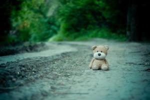 by Marina Shatskih, via Unsplash. Teddy bear alone on a road is a reminder of the loss in Gaza of thousands of infants and children