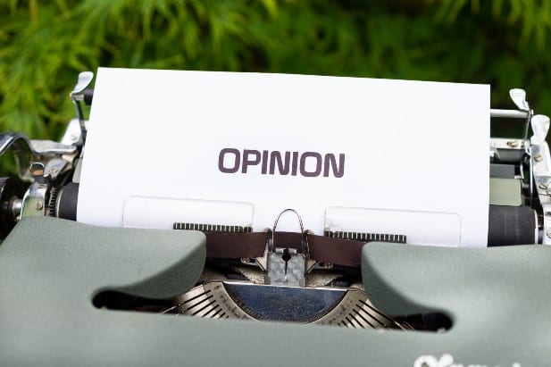 The word "opinion" is typed on a page from a typewriter.
