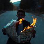 Photo by Esra Korkmaz: https://www.pexels.com/photo/man-sitting-in-the-middle-of-a-road-and-holding-a-burning-newspaper-19300869/