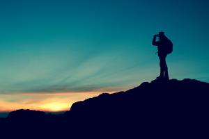 man looking back from top of mountain